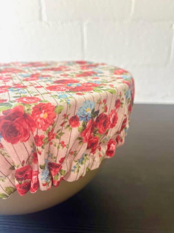 This reversible cotton bowl cover features a rose print on one side and red gingham on the other—an eco-friendly, reusable alternative to plastic wrap.