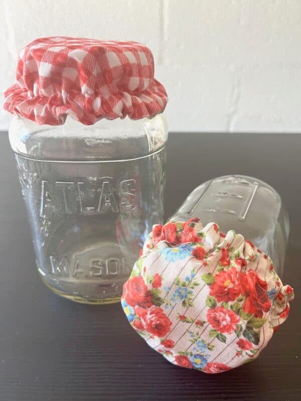 Reversible Cotton Jar Cover – Roses & Red Gingham Picnic Print Breathable, beautiful, and made for your sourdough starter. Whether your starter is bubbling on the counter or you're storing dry goods, this breathable fabric helps protect while allowing airflow. With sweet cottage roses on one side and classic red gingham on the other, your kitchen just got a little more fun (and a lot more functional). Why You'll Love It: Fits Most Mason Jars: Designed to fit both wide-mouth and regular-mouth jars with a secure, flexible elastic edge. Breathable & Starter-Safe: Lets your sourdough starter breathe while keeping dust and debris out—essential for strong, active fermentation. Two-in-One Design: Flip between two prints to match your kitchen vibe or the season. Reusable & Sustainable: Washable, plastic-free, and handmade with care from 100% cotton. Perfect for sourdough starters, dry goods, pantry jars, and more. Pair it with our matching reversible bowl cover for the ultimate kitchen set!